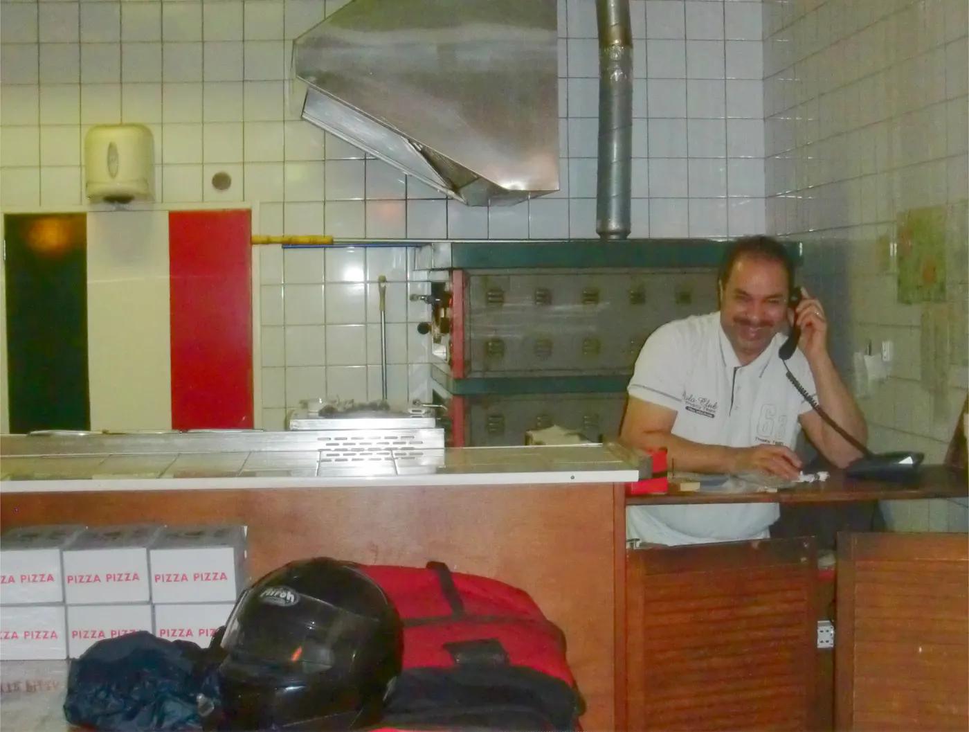 Mario neemt een telefonische bestelling aan in de keuken.